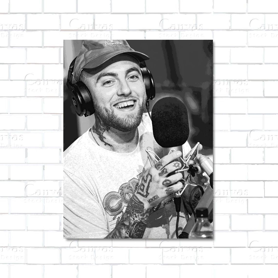 Man with tattoos and headphones in front of a microphone on a white brick wall background